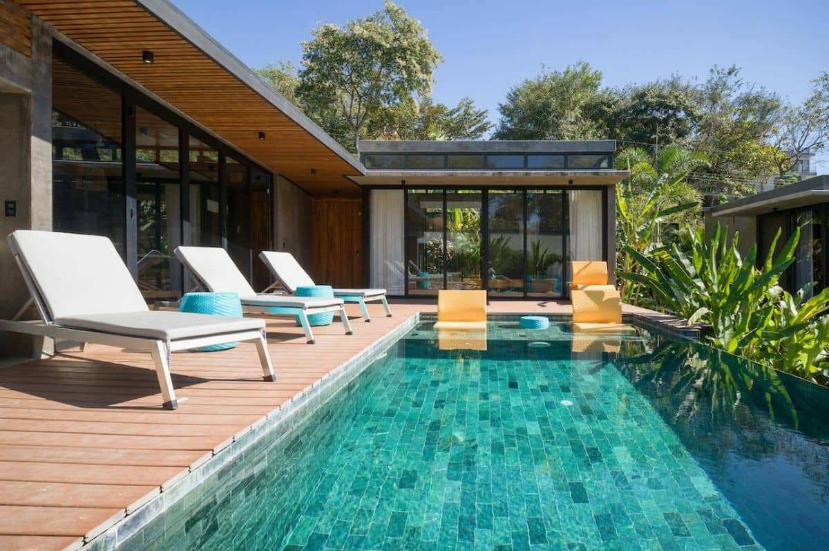 Turquoise swimming pool surrounded by tropical gardens at Villa Aquarena near Tamarindo Beach