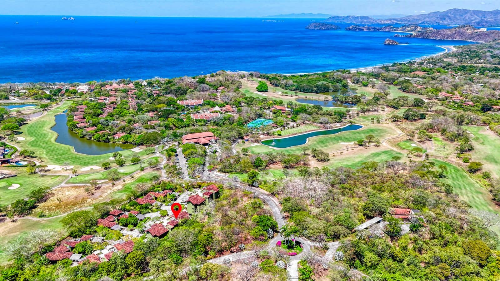 Aerial view of Reserva Conchal featuring the Carao T3-4 condo, lush landscapes, and the pristine ocean.