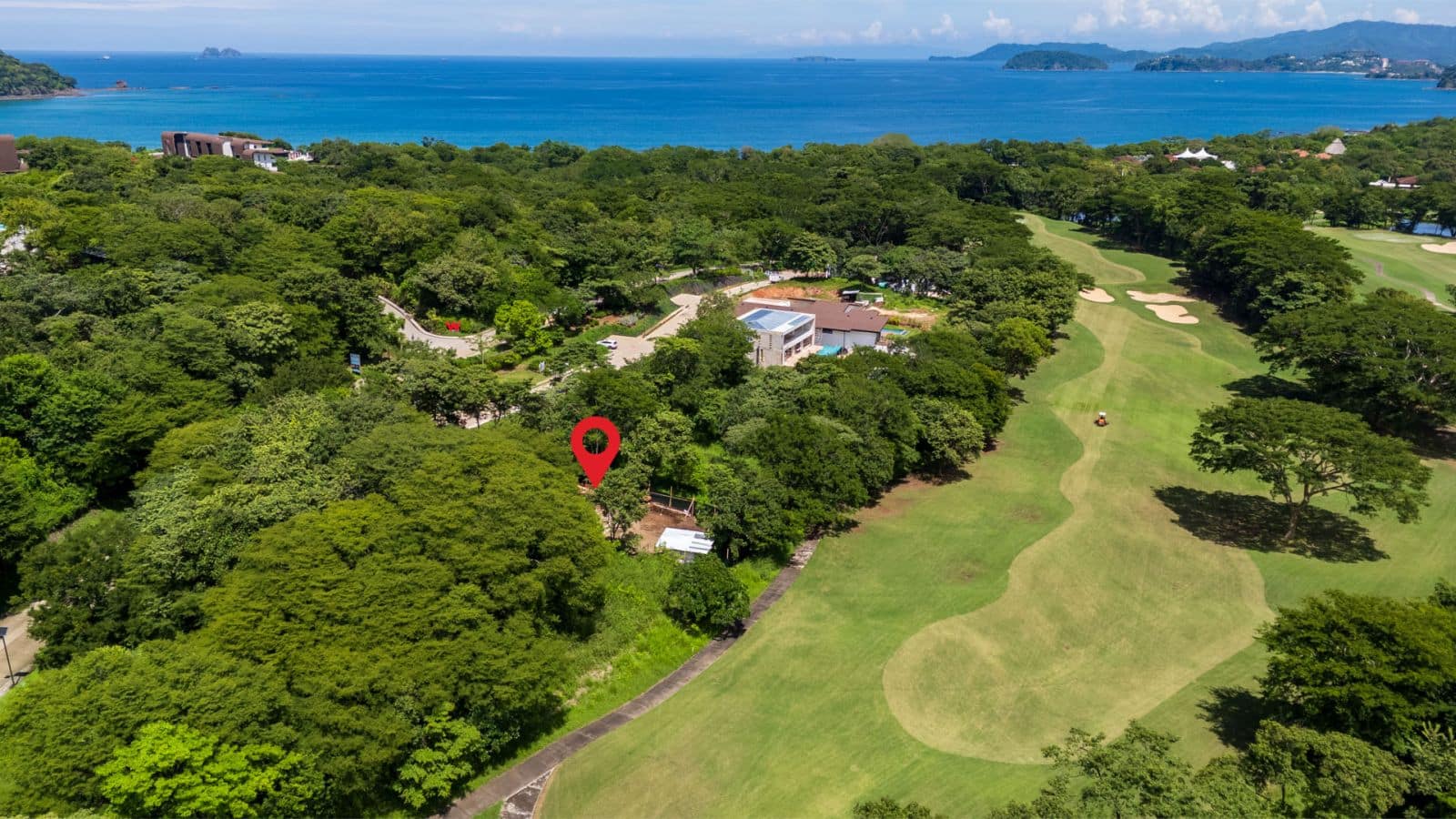 Aerial view of Casa Joya del Bosque in Reserva Conchal, showcasing its lush forest surroundings, infinity pool, and close proximity to Playa Conchal’s white-sand beach.