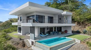 Back view of Villa Oceana featuring an infinity-edge pool, spacious outdoor lounge, and stunning ocean views.