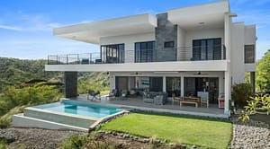 Back view of Villa Oceana featuring an infinity-edge pool, spacious outdoor lounge, and stunning ocean views.
