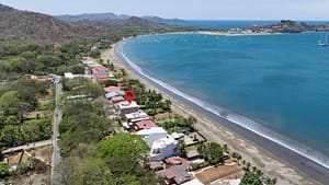 Aerial view of El Destino 1A beachfront condo facing Playa Potrero with ocean and tropical gardens.