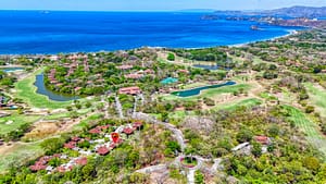 Aerial view of Reserva Conchal featuring the Carao T3-4 condo, lush landscapes, and the pristine ocean.