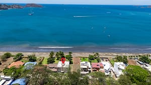 Aerial view of El Destino 1A beachfront condo facing Playa Potrero with ocean and tropical gardens.