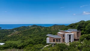 Aerial view of Casa Manta Ray showcasing its luxury design, infinity pool, and stunning proximity to the Pacific Ocean.