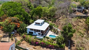 Aerial view of Casa Veranera estate with main house, guest house, lush landscaping, and dipping pool in Playa FlamingO