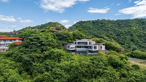 Aerial view of Casa Manta Ray perched atop a mountain, offering panoramic ocean views and luxurious modern design.