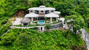 Aerial view of Casa Camari’s stunning backyard, featuring a private pool, jacuzzi, landscaped gardens, and breathtaking mountain views.