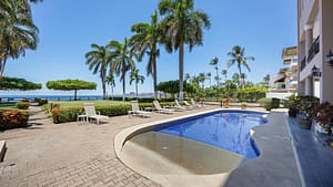 Tropical community pool surrounded by gardens at El Destino 1A, Playa Potrero beachfront condo.