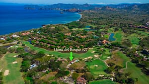Aerial view of Llama del Bosque 27 in Reserva Conchal, showing luxury home, golf course, tropical landscape, and close proximity to Playa Conchal beach