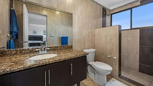 Modern bathroom with granite countertops, walk-in shower, and elegant fixtures at Casa Veranera