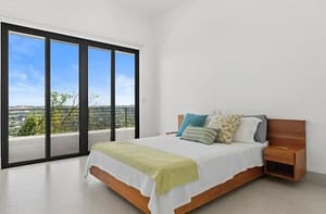Elegant bedroom at Villa Oceana with ocean views, natural light, and modern tropical design.
