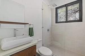 Luxurious bathroom in Villa Oceana with dual vanities, a walk-in shower, and a soaking tub offering elegant tropical design.