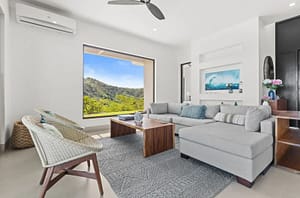 Spacious living room at Villa Oceana with floor-to-ceiling windows, ocean views, and modern tropical design.