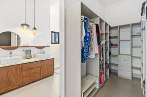 Master bathroom at Villa Oceana featuring a walk-in closet, dual vanities, and a soaking tub with ocean views.