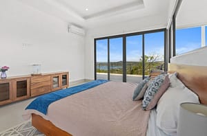 Master bedroom at Villa Oceana with ocean views, a private balcony, and elegant tropical design.
