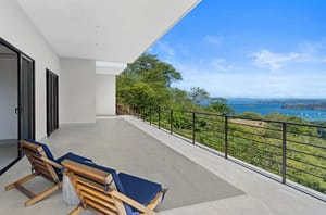 Private balcony at Villa Oceana with covered seating areas and panoramic views of the ocean and tropical surroundings.