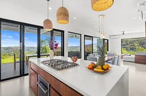 Modern kitchen at Villa Oceana with custom teak cabinetry, quartz countertops, and stainless steel appliances.