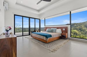 Master bedroom at Villa Oceana with ocean views, a private balcony, and elegant tropical design.