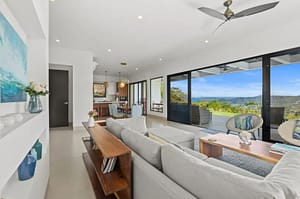 Spacious living room at Villa Oceana with floor-to-ceiling windows, ocean views, and modern tropical design.