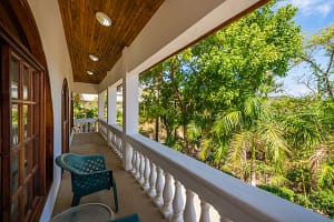 Spacious wraparound terrace with tropical garden and pool views at Casa Margarita, Playa Flamingo