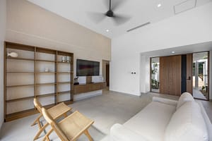 Casa Aguasalada’s living room offers a perfect blend of comfort and sophistication, with teak finishes, plush seating, and breathtaking views of the lush surroundings.
