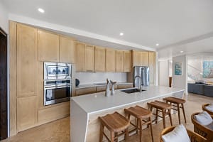 Modern luxury kitchen at Casa Manta Ray with high-end appliances, light wood cabinetry, and ocean views.