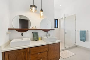 Master bathroom at Villa Oceana featuring a walk-in closet, dual vanities, and a soaking tub with ocean views.