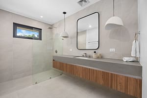 Modern bathroom in Casa Aguasalada, featuring a sleek vanity, walk-in shower, and elegant teak accents.