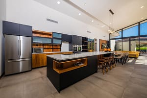 Spacious modern kitchen with high ceilings, sleek cabinetry, large island, and golf course views at Llama del Bosque 27 in Reserva Conchal