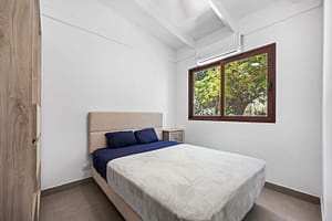 Bright and airy bedroom at Casa Mango with large windows, natural lighting, and tropical garden views in Playa Grande, Costa Rica.