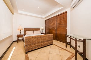 Cozy second bedroom with large windows and modern decor in Naxos 8 condominium.