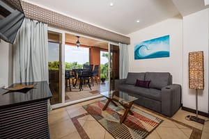 Spacious open-concept living room with modern decor and balcony access in Naxos 8 condominium.