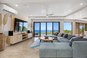 Spacious living room at Casa Manta Ray with ocean views, a 12-seat sectional, and custom wood accents.