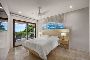 Luxurious bedroom at Casa Manta Ray with ocean views, custom wood furniture, and en-suite bathroom.