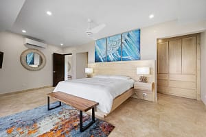 Luxurious bedroom at Casa Manta Ray with ocean views, custom wood furniture, and en-suite bathroom.