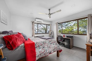 Spacious and bright bedroom in the main house with large windows, scenic views, and a cozy ambiance.
