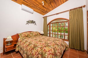 Spacious bedroom with teak wood accents and ocean view at Casa Margarita, Playa Flamingo