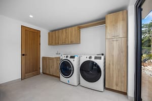 Spacious and modern laundry room in Casa Aguasalada, featuring high-end appliances, sleek cabinetry, and ample storage space.