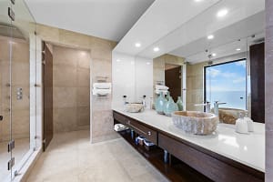 Luxurious ensuite bathroom with custom stone sinks and oversized rain shower overlooking the ocean at Casa Seahorse in Mar Vista, Playa Flamingo.