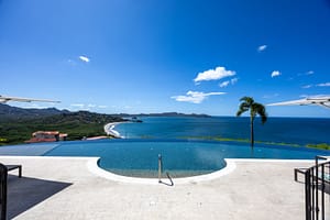 Infinity pool overlooking the Pacific Ocean with lounge chairs and breathtaking panoramic views at 360 Splendor del Pacifico Flamingo.
