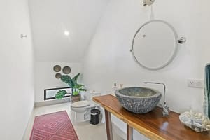 Luxurious bathroom in Villa Oceana with dual vanities, a walk-in shower, and a soaking tub offering elegant tropical design.