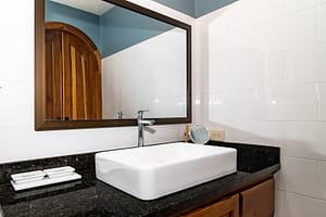 Modern and elegantly designed bathrooms with private en-suite features, luxury finishes, and stunning rainforest views in a mountain retreat near Arenal Volcano, Costa Rica.