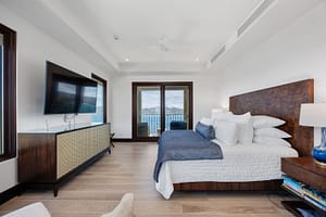 Elegant ocean-view bedroom with floor-to-ceiling windows, a plush bed, and direct access to a private veranda at 360 Splendor del Pacifico Flamingo.