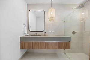 Modern bathroom in Casa Aguasalada, featuring a sleek vanity, walk-in shower, and elegant teak accents.