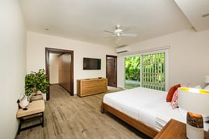 Elegant and spacious bedroom at Casa Kenya, featuring luxurious bedding, modern decor, and serene tropical views in Hacienda Pinilla, Costa Rica.