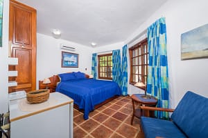 Spacious bedroom with teak wood accents and ocean view at Casa Margarita, Playa Flamingo