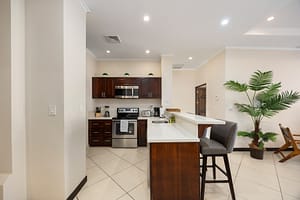 Modern kitchen with stainless steel appliances, dark wood cabinets, and breakfast bar at Flamingo Towers 11 in Playa Flamingo.