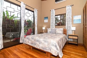 Spacious and elegantly designed bedrooms with panoramic views, queen-size beds, and modern furnishings in a luxury mountain retreat near Arenal Volcano, Costa Rica.