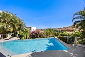 Saltwater pool with ocean and mountain views at Casa Nalifos in Playa Flamingo, Costa Rica